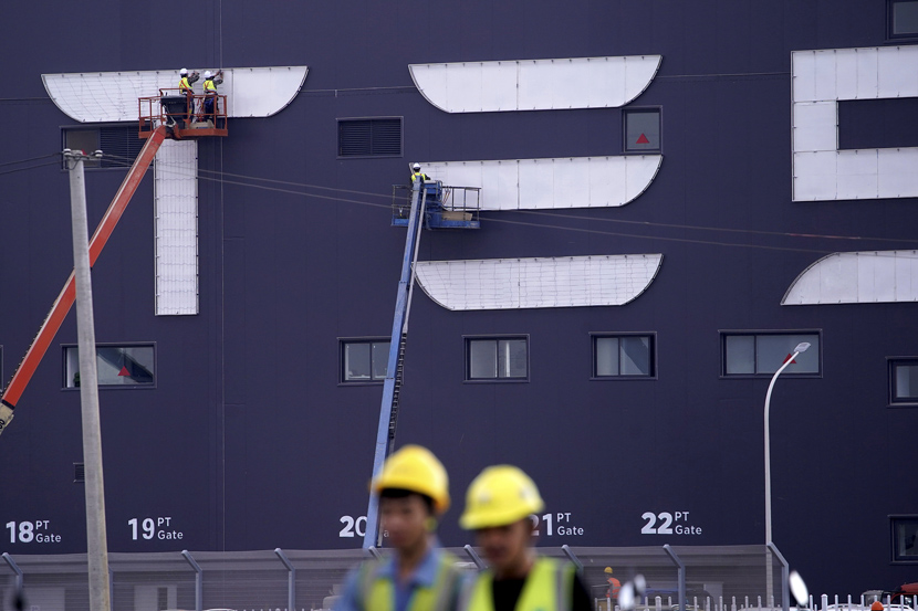 Workers on cranes install the logo for Tesla Gigafactory 3 at the Lingang Area in Shanghai, Oct. 18, 2019. Tesla Gigafactory 3 is expected to begin production at the end of 2019. Aly Song/Reuters/VCG