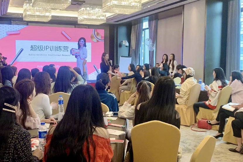 Relationship guru Ayawawa (standing, in black) gives a speech during a training course, October 2019. From @ Ayawawa on Weibo