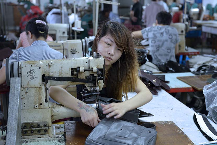 Zheng Ting works in a garment processing factory workshop in Dongguan, Guangdong province, June 8, 2012. Zhan Youbing for Sixth Tone