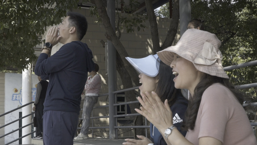 Parents of young players cheer during a soccer match in Shanghai, October 2019. Sixth Tone
