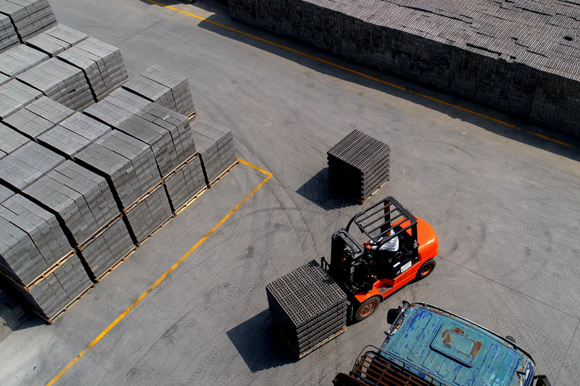 A forklift transfers bricks made from construction waste at a renewable resources company in Nantong, Jiangsu province, March 29, 2019. Qiu Wenshan/VCG