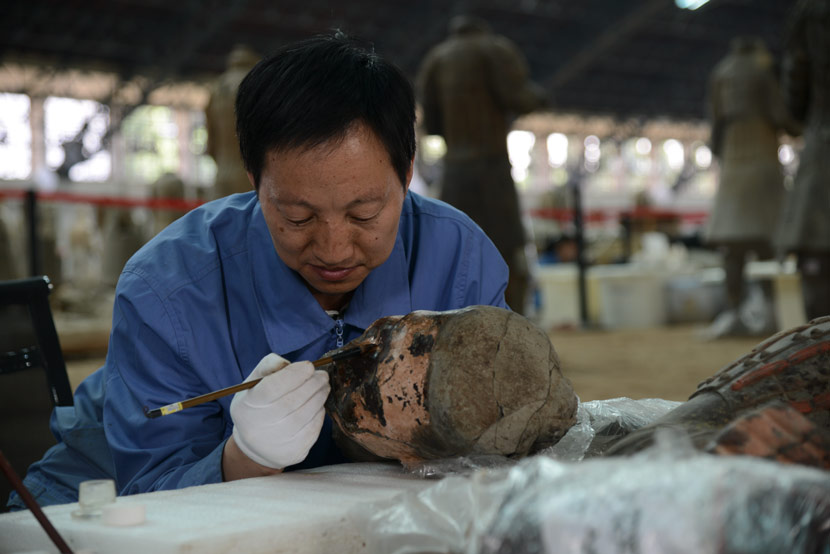 Restorer Lan Desheng fixes the head of a terra-cotta warrior at the Emperor Qin Shi Huang Mausoleum Museum in Xi’an, Shaanxi province, 2013. Courtesy of Lan Desheng