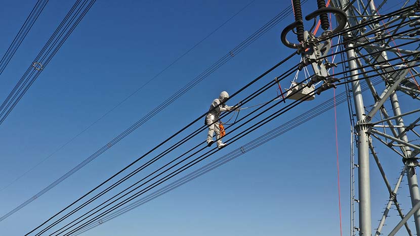 Electrical worker Liu Hongji does the first live work on a 1000kV AC ultra-high voltage (UHV) transmission line in Cangzhou, Hebei province, Nov. 19, 2019. Hu Xiaolong/VCG