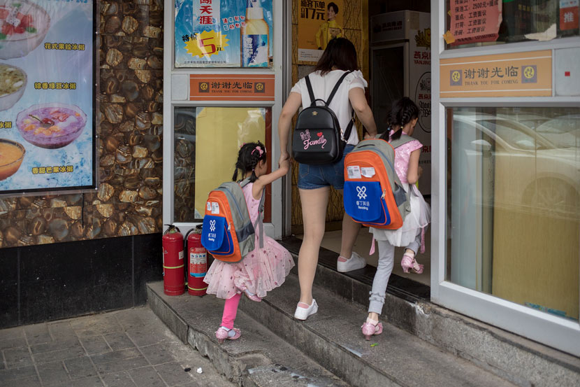 A mother takes her children to lunch after an English training class in Beijing, May 26, 2018. Li Jianguo/VCG