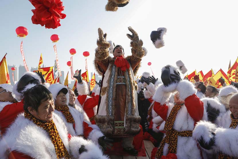 People celebrate after hauling a block of ice during the 2019 Ice Collecting Festival on the frozen Songhua River in Harbin, Heilongjiang province, Dec. 7, 2019. Lü Pin/CNS/VCG