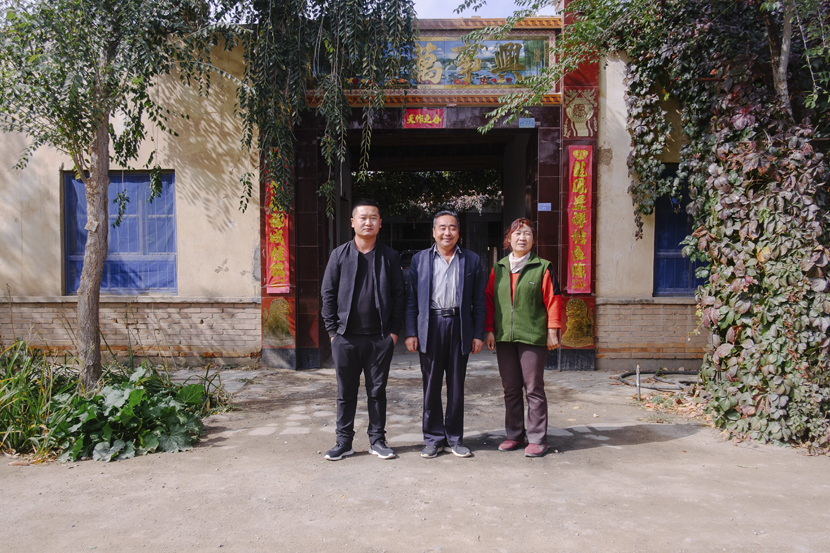 Liu Hongyou (center) poses for a photo with his family members in front of their house in Minqin County, Gansu province, Oct.14, 2019. Wu Huiyuan/Sixth Tone