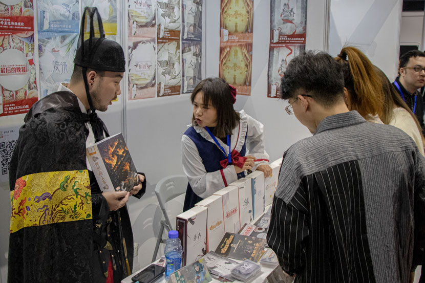 Liu Shilei and a friend chat with visitors at the International Mystery Game Expo in Shanghai, Nov. 14, 2019. Kenrick Davis/Sixth Tone