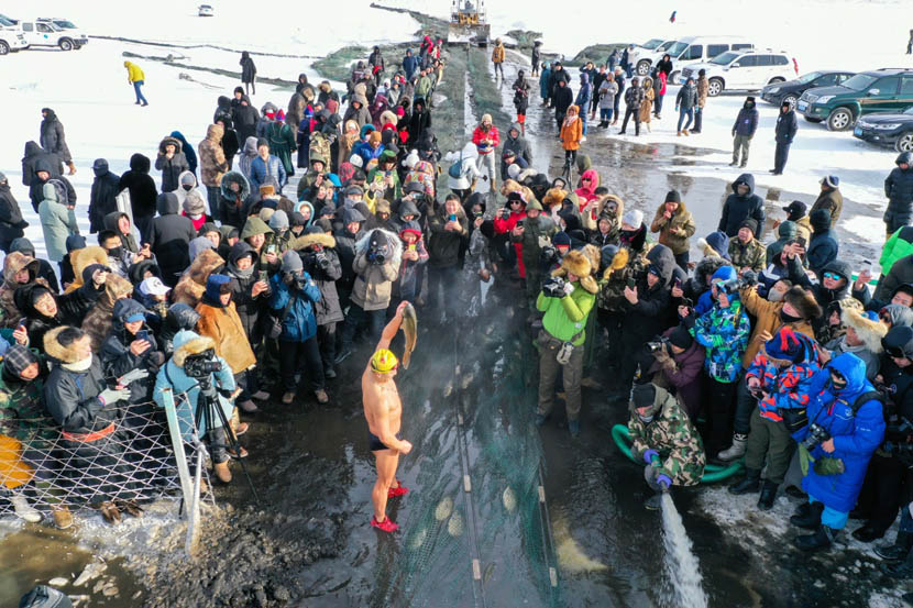People gather to watch fishers haul in their catch on the partially frozen Nuogan Lake in the Hulun Buir Grasslands of Inner Mongolia, Dec. 18, 2019. Liu Lei/Xinhua