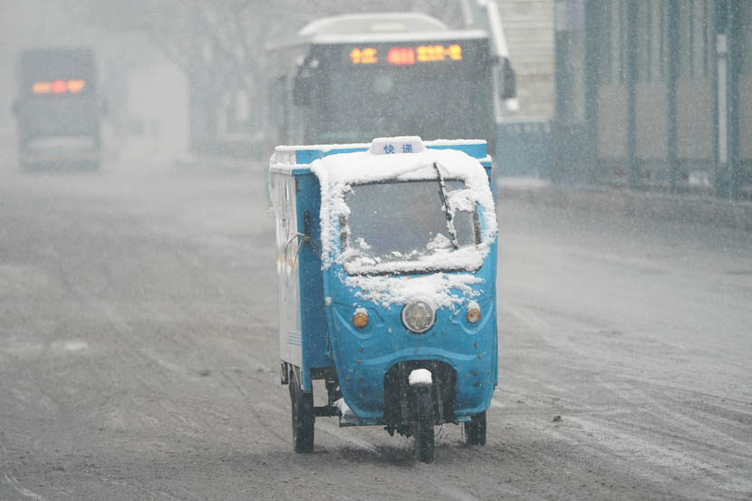 Snow obscures the windshield of a courier’s motorized tricycle in Beijing, Dec. 16, 2019. Qu Zonghuan/Xinhua