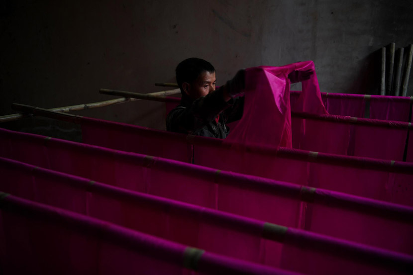 A craftsman dries thin sheets of cotton before rolling them into 1.2-meter sticks of joss paper, which are commonly burned as offerings, in Tonghai County, Yunnan province, Nov. 28, 2019. Kang Ping/CNS/VCG