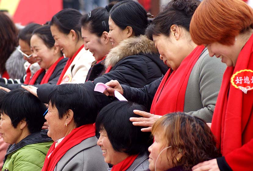 Women who received public awards for good behavior groom their mothers-in-law in Jiyuan, Henan province, March 8, 2018. Tuchong
