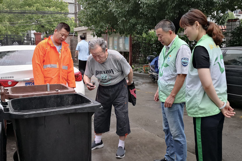 Volunteers explain waste sorting to an elderly resident in Shanghai, June 27, 2019. IC