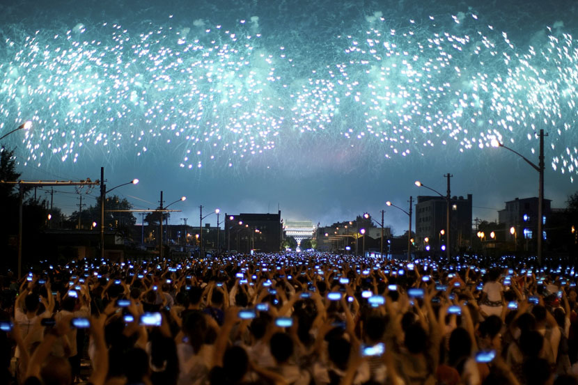 People raise their phones to the sky to record a Beijing fireworks show celebrating the 70th anniversary of the founding of the People’s Republic of China, Oct. 1, 2019. Aly Song/Reuters/VCG