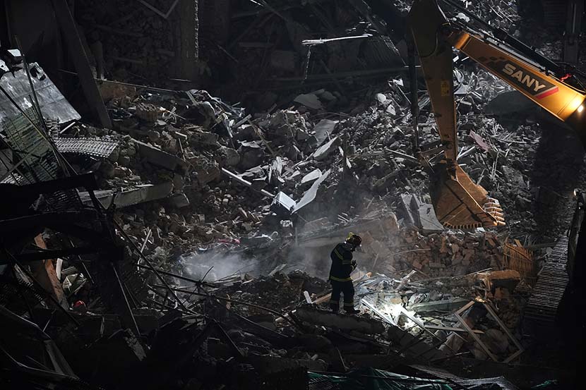 A firefighter works at the site where a building collapsed in Shanghai, May 16, 2019. Ten people were killed when the roof of a Shanghai commercial building caved in on May 16. Aly Song/ Reuters/VCG