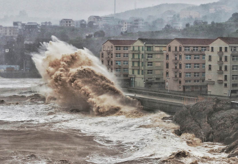 Large waves crash against a sea wall in front of a row of residential buildings in Taizhou, Zhejiang province, Aug. 9, 2019. China issued a red alert ahead of Typhoon Lekima making landfall in Zhejiang province. VCG