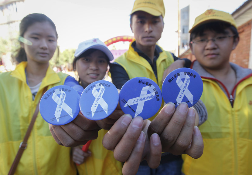 Volunteers pose for a photo with White Ribbon badges during an activity on anti-domestic violence in Kunming, Yunnan province, Nov. 25, 2019. Tuchong