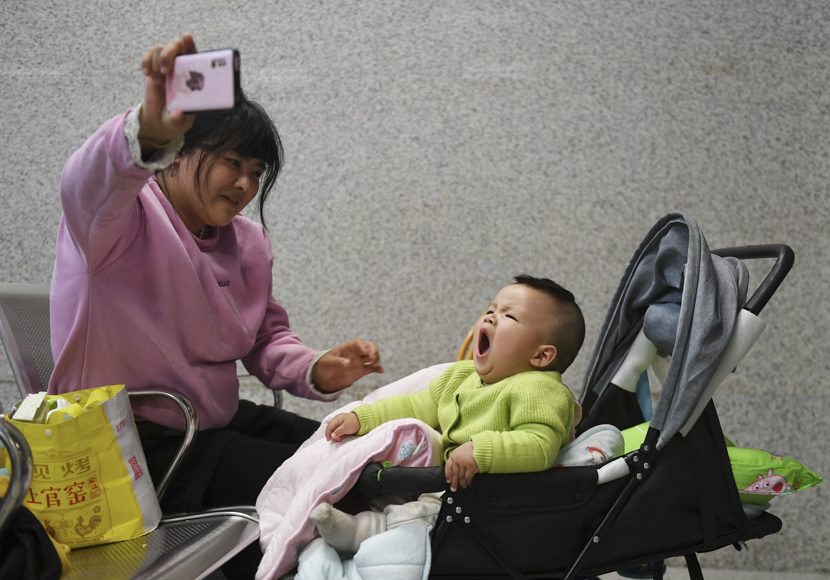 A mother plays with her child at a railway station during the first day of the Spring Festival travel rush in Shenzhen, Guangdong province, Jan. 10, 2020. Mao Siqian/Xinhua