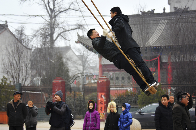 Villagers play on a swing, a traditional local custom celebrating the upcoming Spring Festival, in Zhouzhi County, Xi’an, Shaanxi province, Jan. 9, 2020. Liu Xiao/Xinhua
