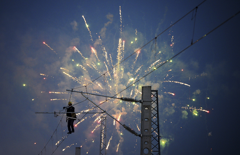 A worker sets up electric cables during a display of fireworks in Xi’an, Shaanxi province, Jan. 7, 2020. Liu Xiao/Xinhua