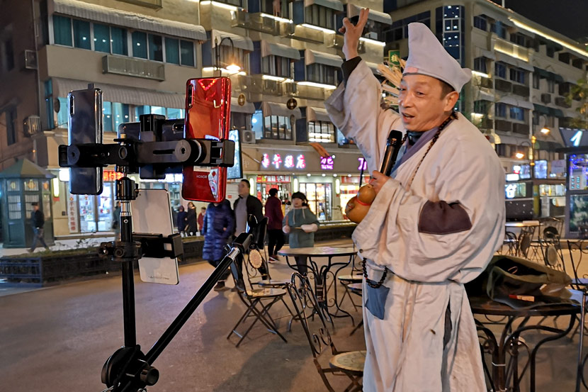 A livestreamer wearing a monk outfit performs traditional songs in Hengdian Town, Zhejiang province, Jan. 14, 2020. Kenrick Davis/Sixth Tone