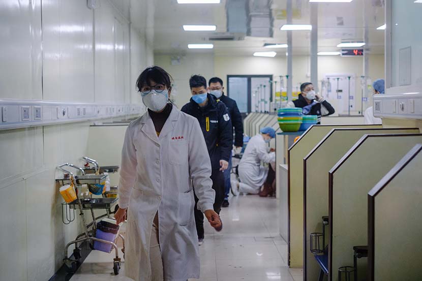 Medical workers walk through an outpatient IV ward at Ruijin Hospital in Shanghai, Jan. 23, 2020. Wu Huiyuan/Sixth Tone