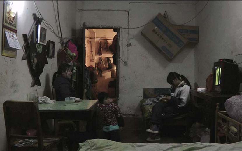 A mother and her two daughters in a small shared living area. Courtesy of Zhu Shengze