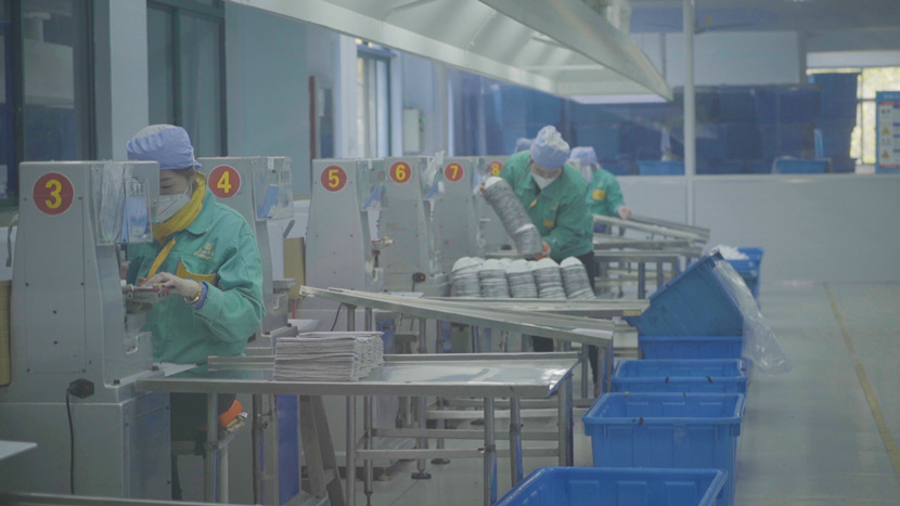 Workers assemble face masks at a factory in suburban Shanghai, Jan. 31, 2020. Tang Xiaolan/Sixth Tone