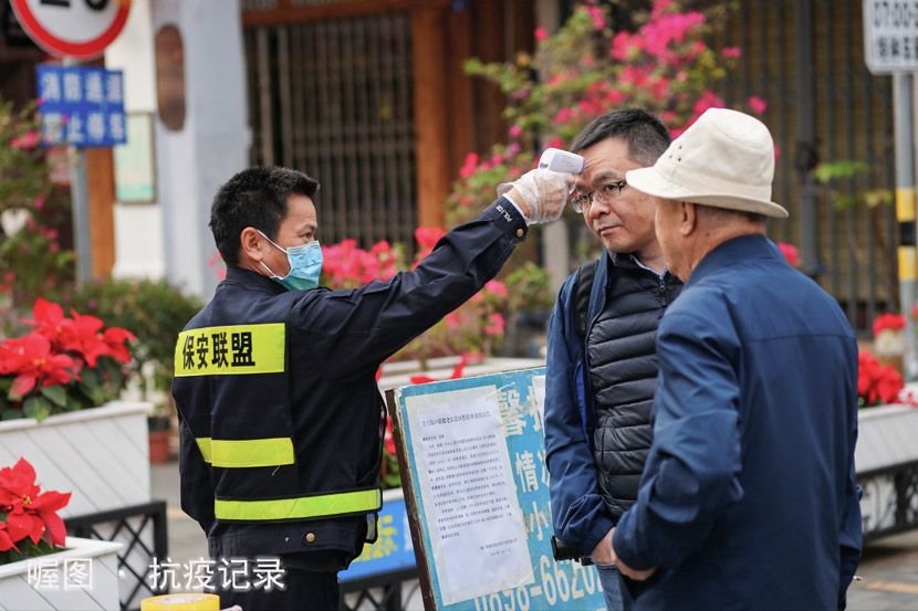 A security guard tests the body temperature of a passerby in Haikou, Hainan province, Jan. 29, 2020. From “Epidemic Resistance Record,” an online project featuring the work of photographers from several Chinese cities. Courtesy of Shun Zi via 喔图Alltuu
