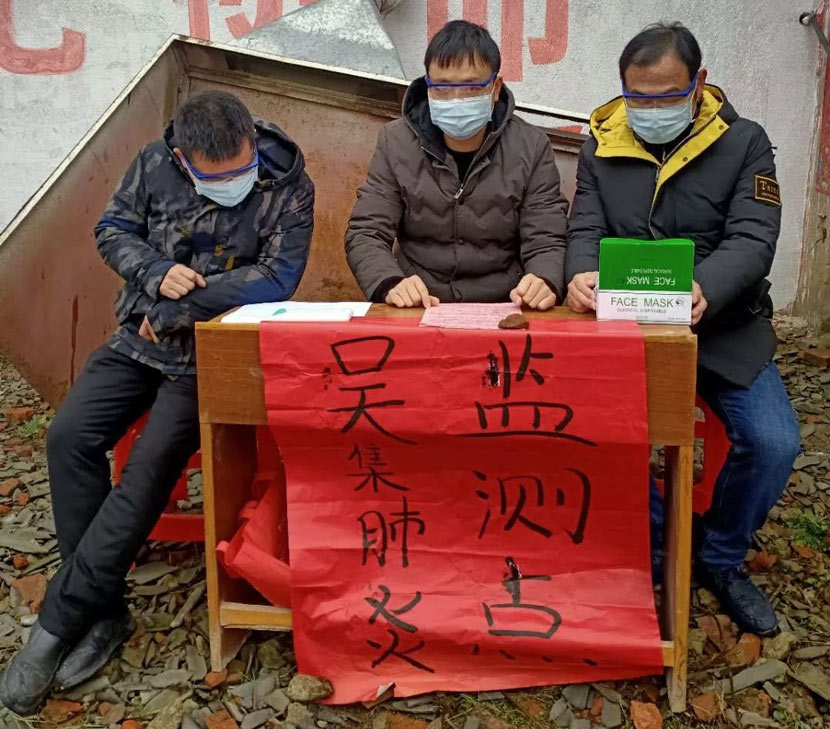 Officials sit at a pneumonia monitoring spot in Wuji Village, Xiaogan, Hubei province, January, 2020. From 孝感环境保护 on WeChat