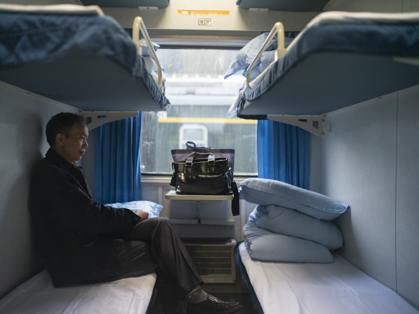 A passenger sits on a cot, waiting for the train to depart in Guangzhou, Guangdong province, Jan. 17, 2020. Zhang Zhitao for Sixth Tone