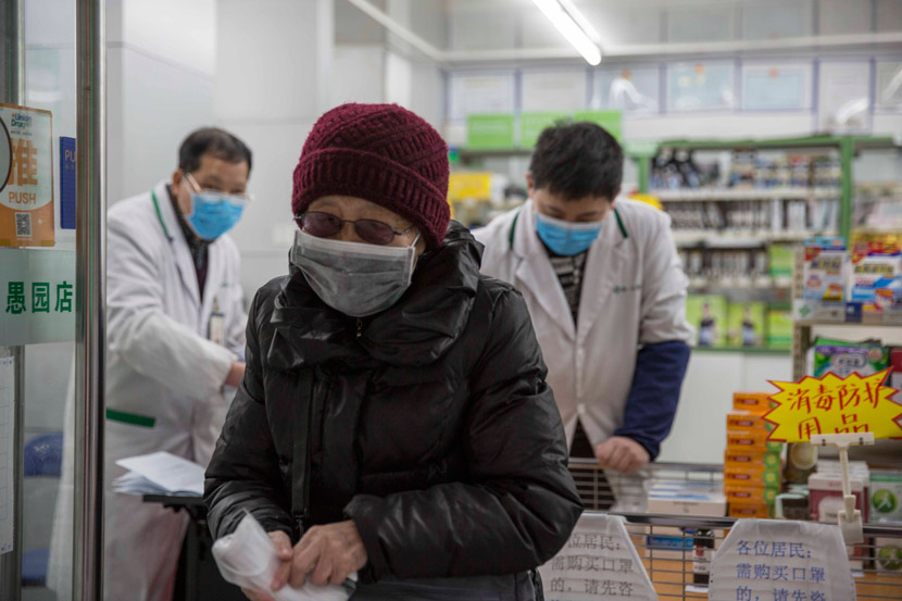 An elderly woman exits a pharmacy after purchasing five face masks in Shanghai, Feb. 5, 2020. Yi Chuan for Sixth Tone