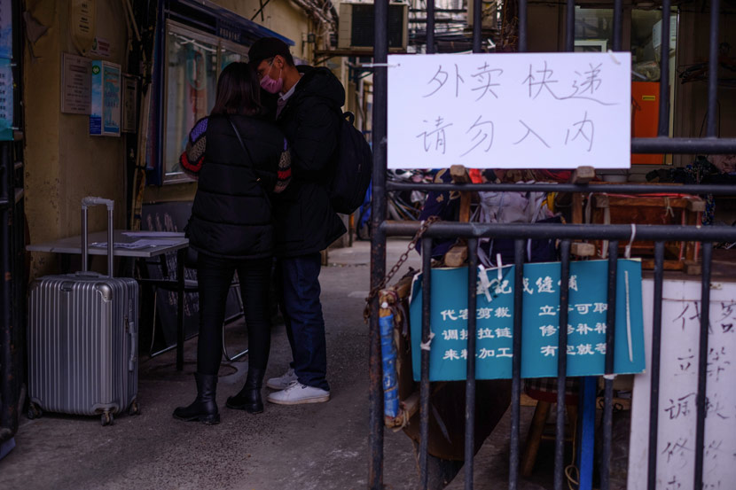 A man who has just returned to Shanghai fills out a registration form at the entrance of a residential complex, Shanghai, Feb. 5, 2020. Wu Huiyuan/Sixth Tone