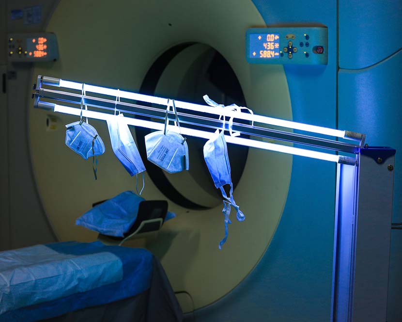 Masks are disinfected by a fluorescent light in a CT Scan Room at a hospital in Ningbo, Zhejiang province, Feb. 5, 2020. Because of the shortage in medical supplies, doctors and nurses are resorting to thrifty methods. Sui Feng for Sixth Tone