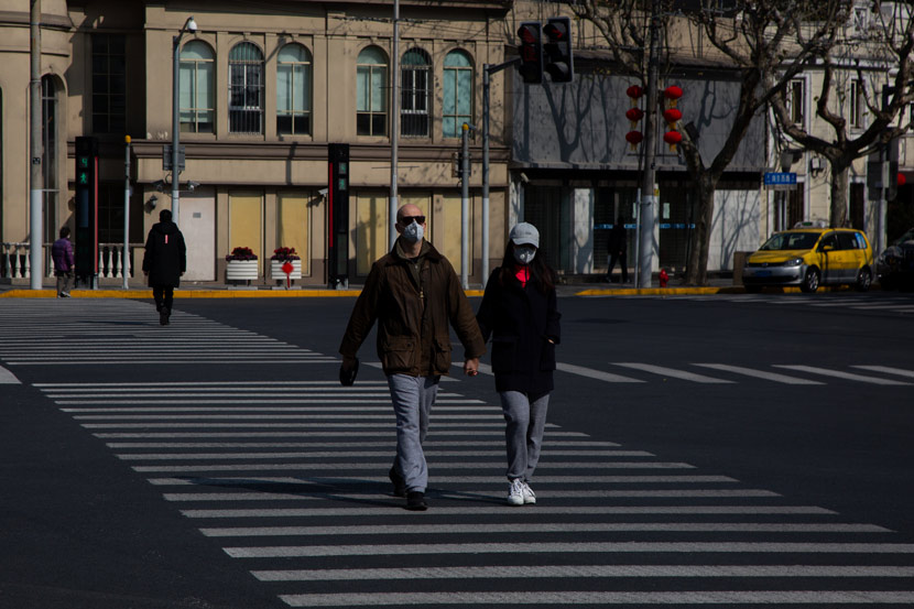 People wearing masks cross a road in Shanghai, Feb. 5, 2020. Shi Yangkun/Sixth Tone