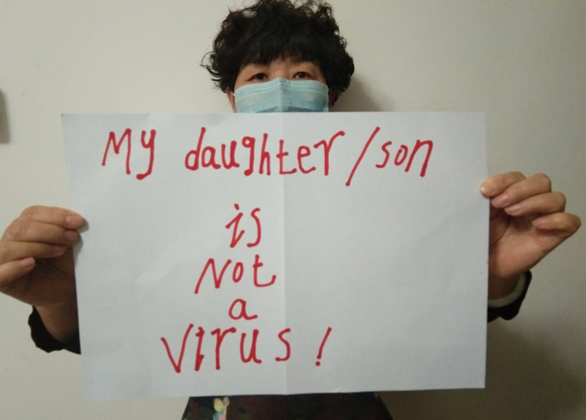 A woman poses with a sign saying “My daughter/son is not a virus.” From @yang_lingyan on Twitter