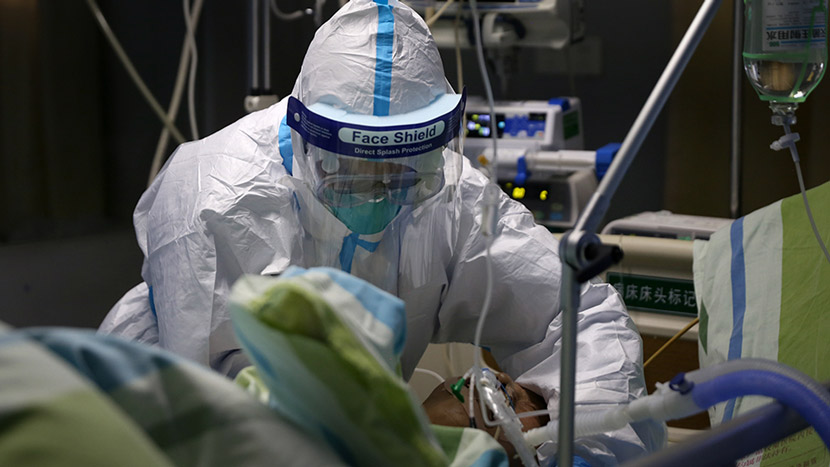 A medical worker in full protective gear attends to a patient at Zhongnan Hospital of Wuhan University, Hubei province, Jan. 23, 2020. Zheng Chaoyuan and Wei Jiaming for Sixth Tone