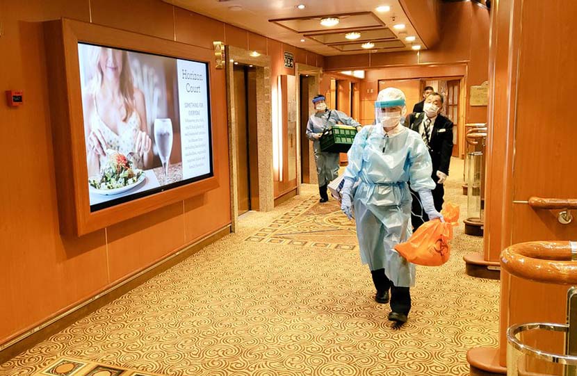 Medical workers walk down a hallway on the Diamond Princess cruise ship, currently under quarantine in Yokohama, Japan, Feb. 6, 2020. Xinhua