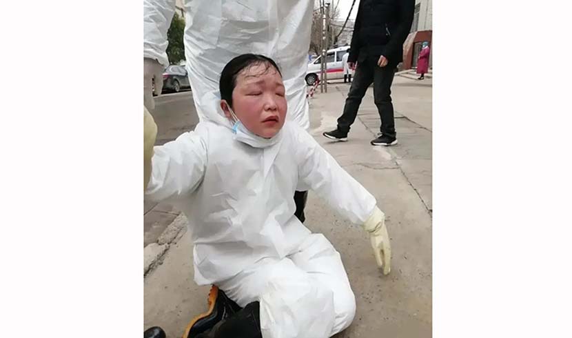 A medical worker faints from exhaustion outside a hospital in Hanchuan, Hubei province, February 2020.