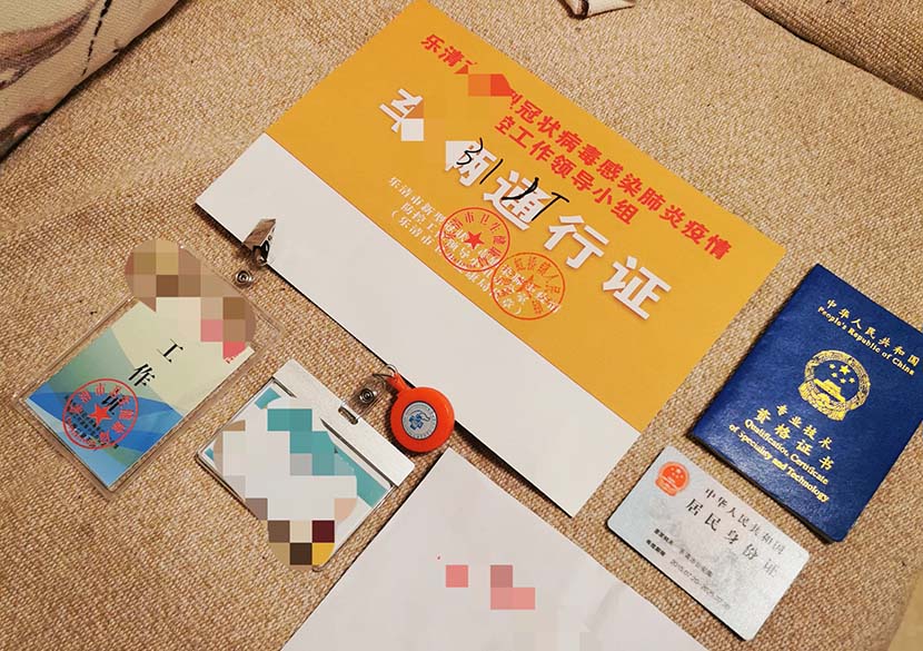 Wenzhou residents have to show several passes, ID cards, and other documents to staff in their residential complexes to leave home and go to work. Courtesy of Duoduo