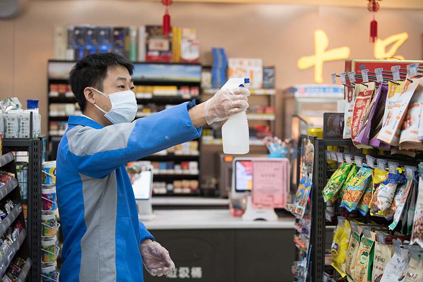 A staff member sterilizes a  convenience store in Wenzhou, Zhejiang province, Feb. 2, 2020. Xinhua