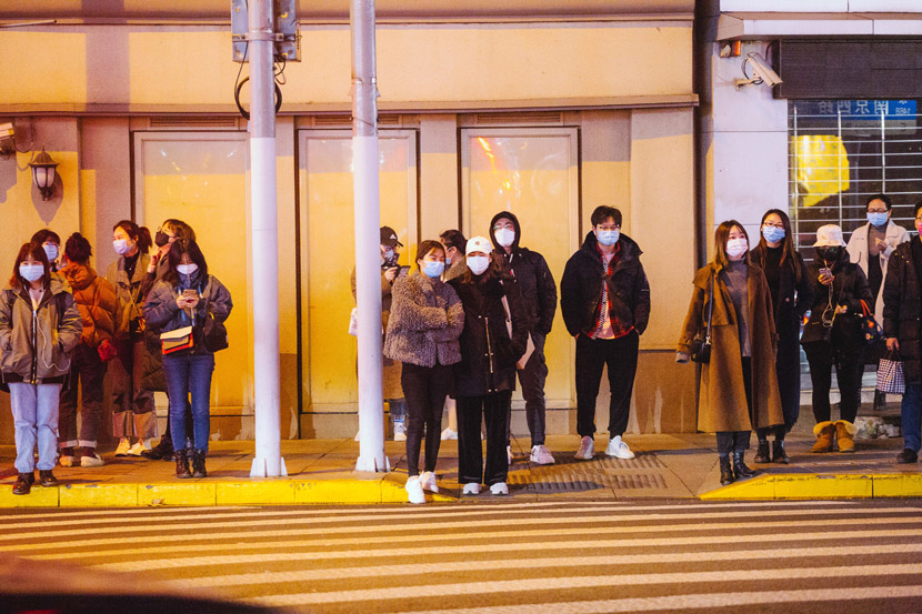 Pedestrians wait to cross the street in Shanghai, Feb. 27, 2020. Wu Huiyuan/Sixth Tone