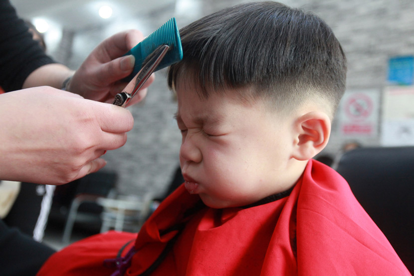 A child gets his bangs trimmed for the Longtaitou Festival in Yangzhou, Jiangsu province, Feb. 24, 2020. Held on the second day of the second month of the lunar calendar, Chinese traditionally mark the festival by getting a haircut. Meng Delong/IC