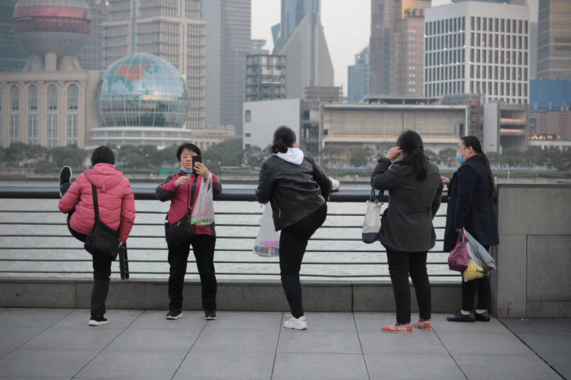 Sightseers enjoy the view from the Bund in Shanghai, Feb. 24, 2020. Chen Jianhui for Sixth Tone