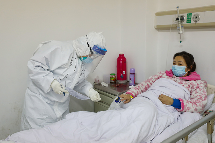 A medical worker checks a patient’s blood-oxygen level at Jinyintan Hospital in Wuhan, Hubei province, Feb. 13, 2020. Yuan Zheng/Changjiang Daily