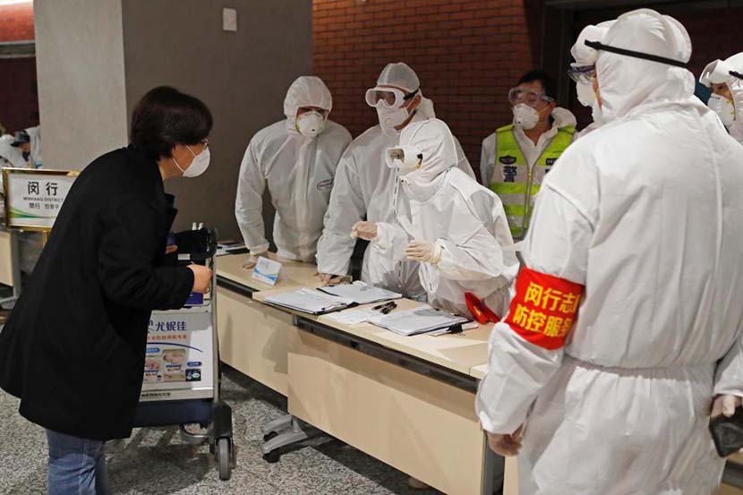 A woman registers at a public health checkpoint after passing through immigration at Shanghai Hongqiao International Airport, March 7, 2020. Yin Liqin/CNS