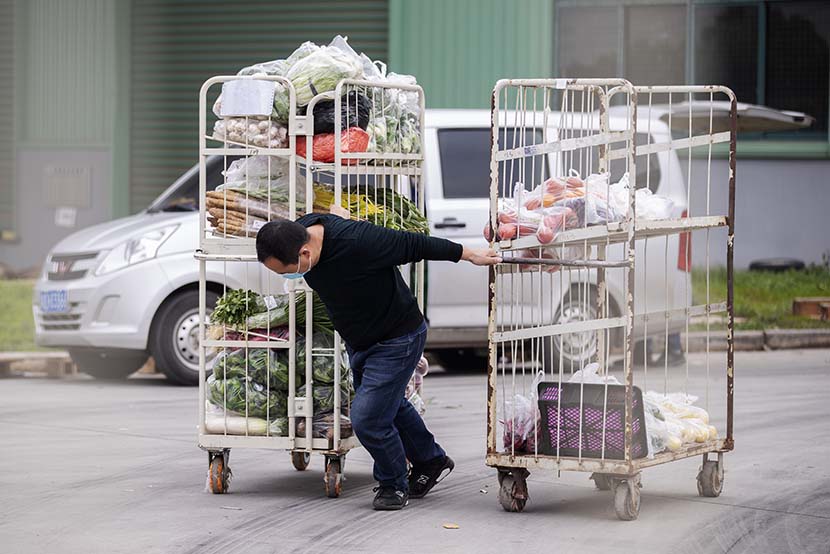 A man hauls two carts of vegetables in Wuhan, Hubei province, March 7, 2020. Xinhua