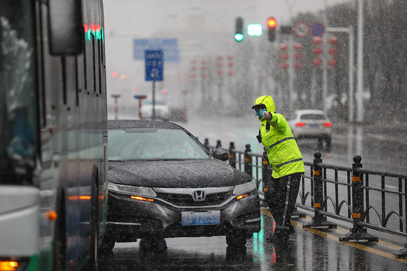 A police officer directs traffic in Wuhan, Hubei province, Feb. 15, 2020. Yuan Zheng for Sixth Tone