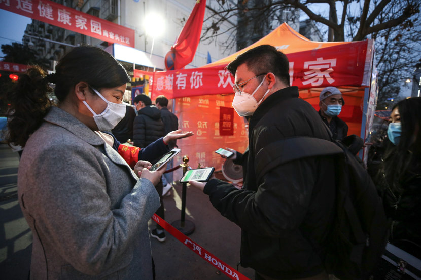 A social worker checks a QR code for monitoring health at the entrance of a residential community in Xi’an, Shaanxi province, March 9, 2020. Tian Ye/IC