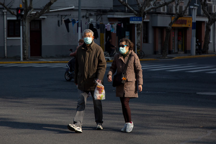An elderly couple walks along a street in Shanghai, Feb. 12, 2020. Shi Yangkun/Sixth Tone