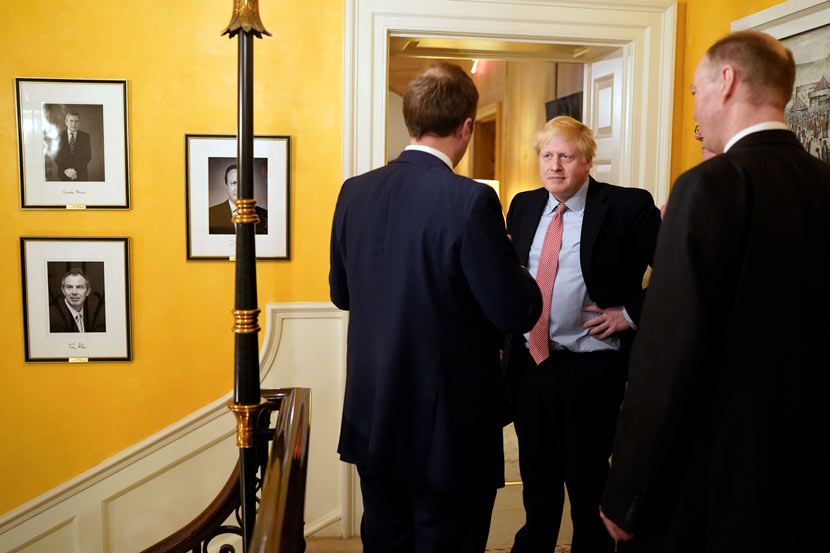 U.K. Prime Minister Boris Johnson (middle) speaks with officials after a press conference about the British government’s response to the COVID-19 pandemic, London, March 17, 2020. Xinhua